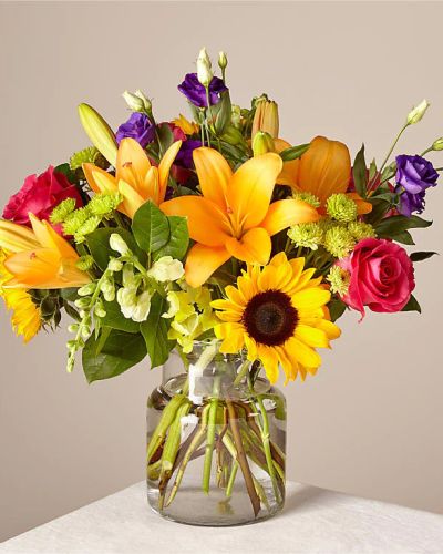 Make this day their best day. Our local florist handcraft a colorful array of flowers in a clear glass vase to create a celebration in bloom. Perfect to give for a special reason or to simply share a smile.