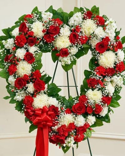 It's not always easy to express your feelings when someone you love has passed on. With this floral tribute, your deepest condolences and undying love are clearly on display. Our expert florists craft red and white roses, football mums, carnations and more into an exquisite open-heart arrangement to help you convey your sympathies. Traditionally sent directly to the funeral home by family members or friends and displayed on a stand.