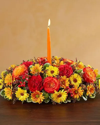 <p>Send your warmest wishes to the people you love with our colorful autumn centerpiece. This traditional table arrangement is designed with radiant blooms and finished off with an orange taper candle to cast a cozy glow over seasonal gatherings.</p>